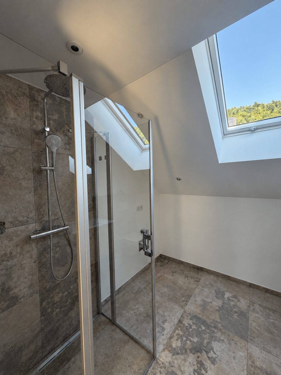 Dusche der Ferienwohnung Karl mit Glasabtrennung und Dachfenster