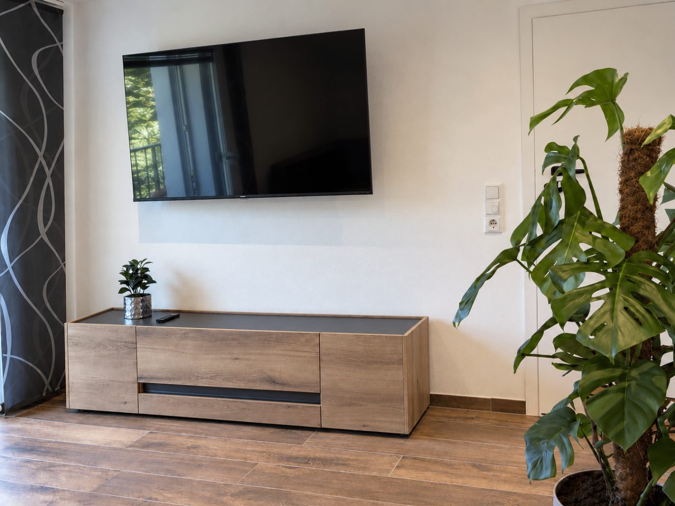 Wohnbereich der Ferienwohnung Karl mit Smart-TV und Sideboard