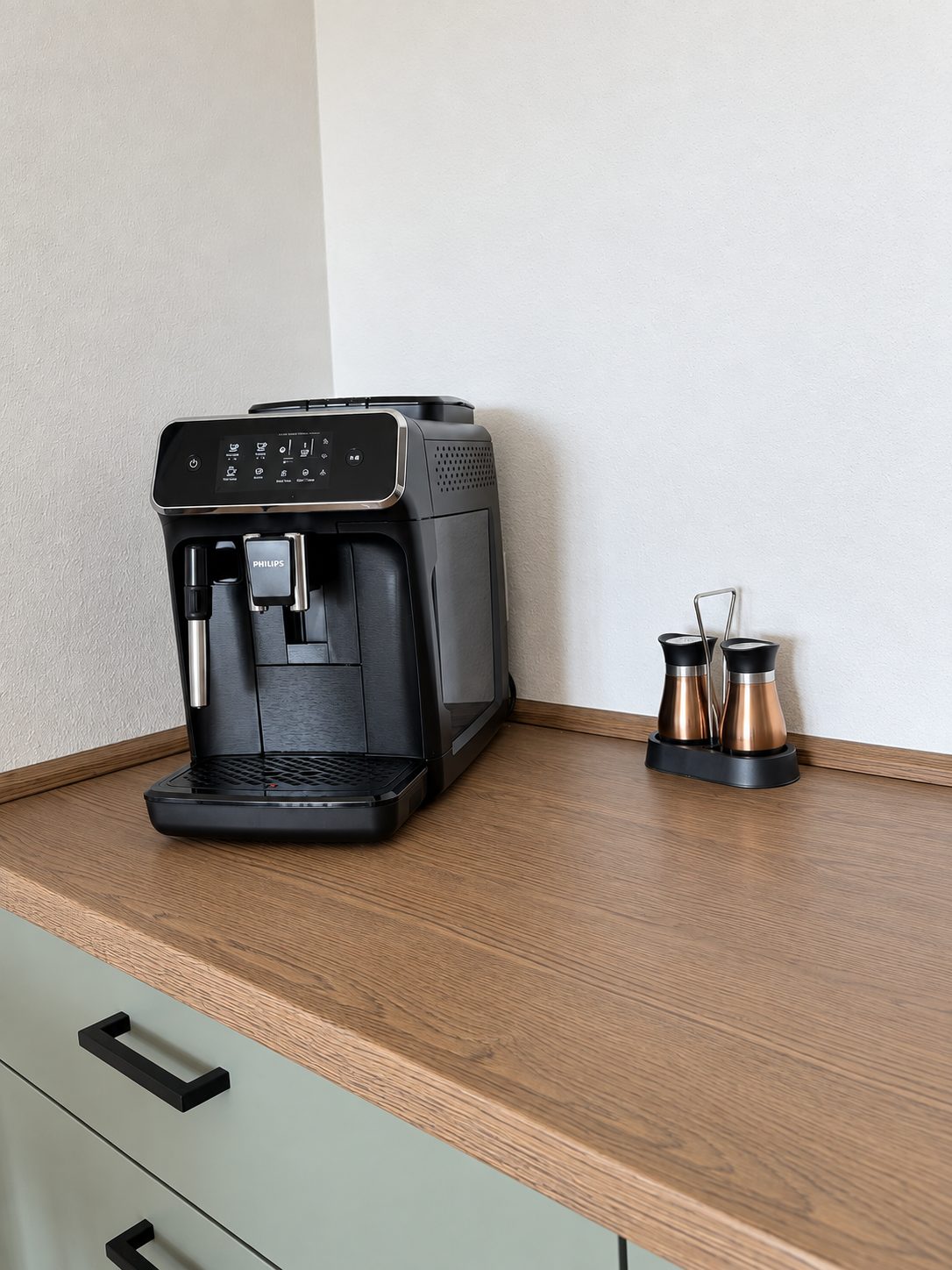 Philips Kaffeevollautomat auf der Holzarbeitsplatte der grünen Küche in der Ferienwohnung Liserl
