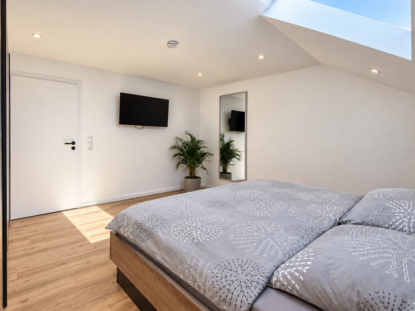 Schlafzimmer der Ferienwohnung Karl mit Doppelbett, Dachfenster und Fernseher