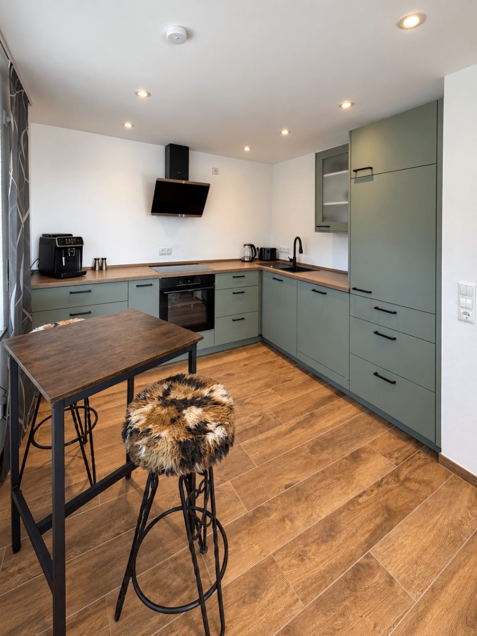 Separate Küche der Ferienwohnung Liserl mit Backofen, Induktionskochfeld und Bartisch